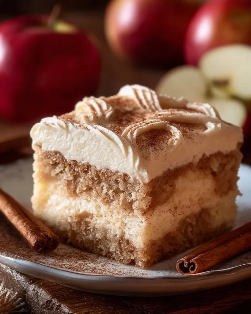 Applesauce cake topped with cinnamon cream cheese frosting on a plate