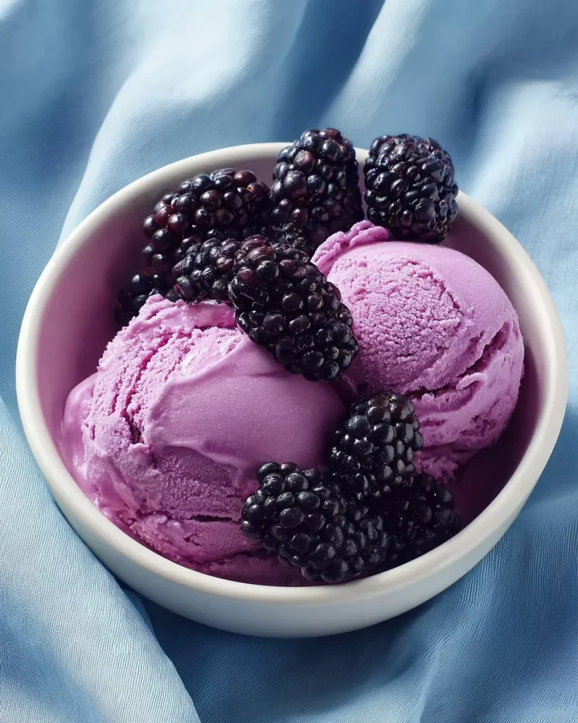 Homemade Blackberry Ice Cream in a bowl topped with fresh blackberries