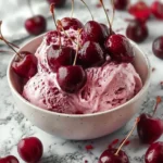 Delicious Cherry Cheesecake Fluff dessert in a bowl with cherries on top.