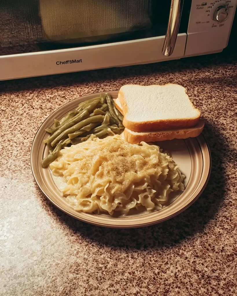 Plate of chicken and noodles served over mashed potatoes for a hearty dish.