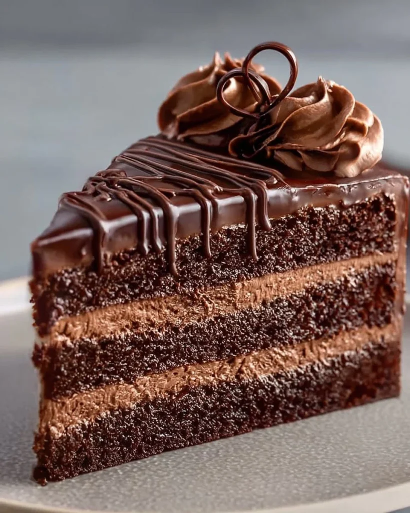 Fluffy chocolate cake topped with creamy frosting and chocolate shavings