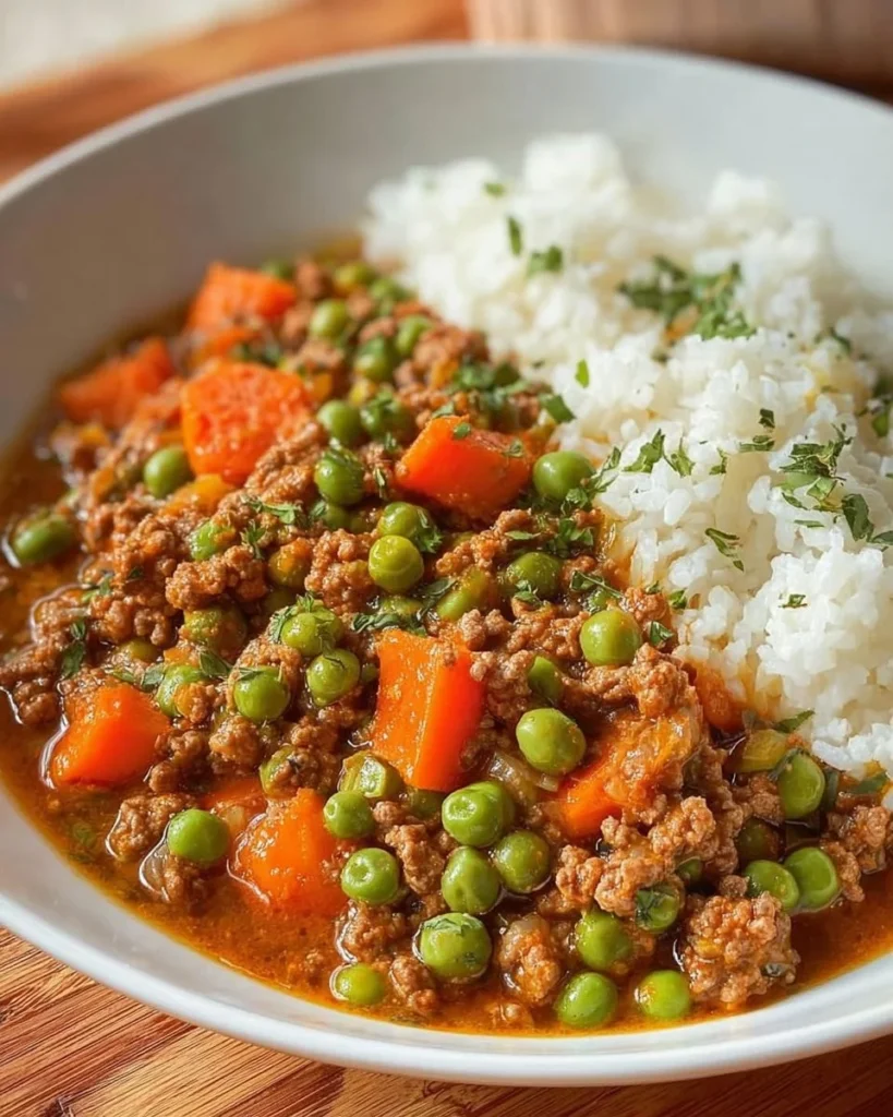 Hearty ground beef and veggie stew served with rice in a bowl