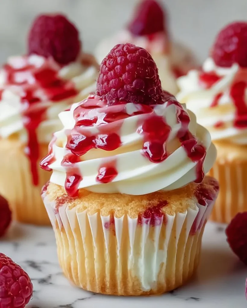 Delicious raspberry cheesecake cupcakes topped with fresh raspberries
