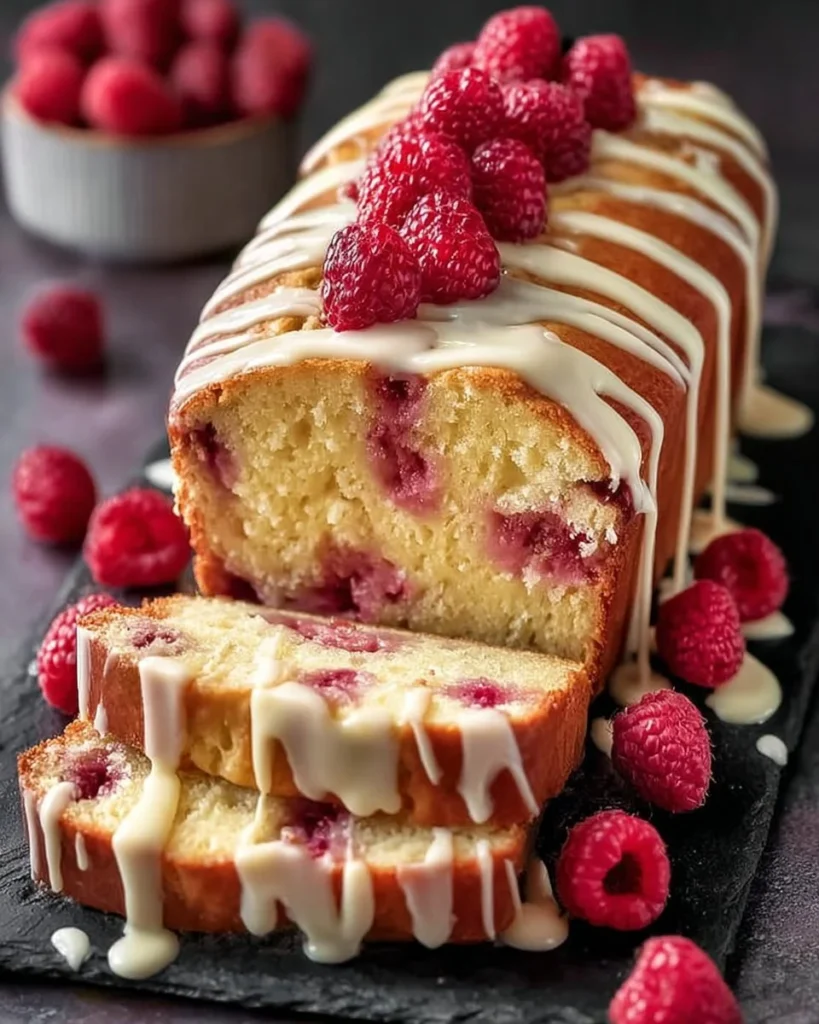 Slice of heavenly white chocolate raspberry cake with raspberries and chocolate drizzle