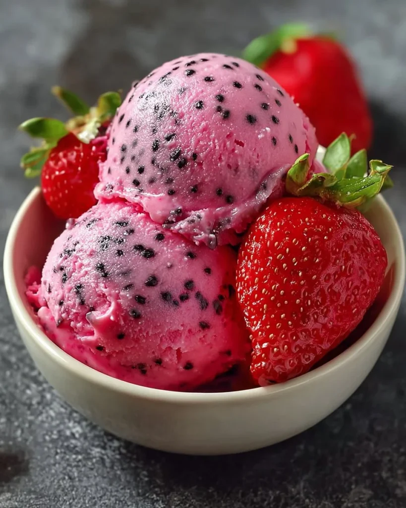 Bowl of homemade dragonfruit strawberry ice cream topped with fresh fruit.