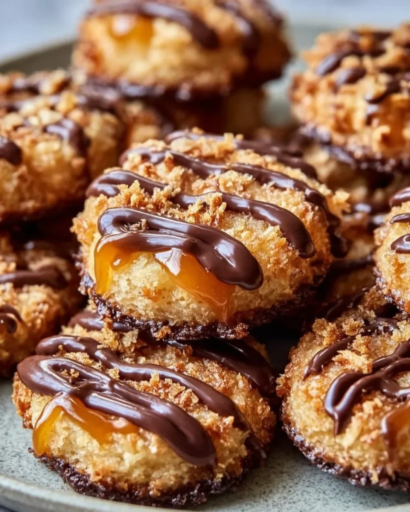 Homemade Samoas Cookies topped with chocolate and coconut on a plate.