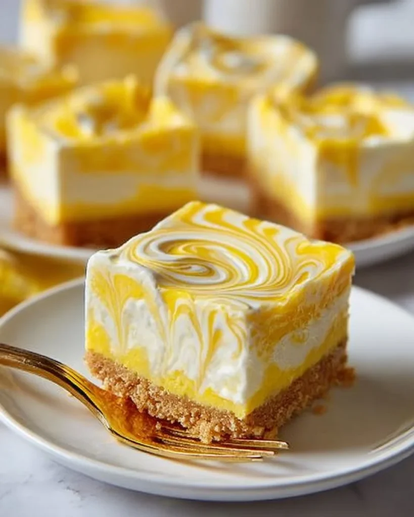 Irresistible lemon swirl cheesecake squares on a white plate