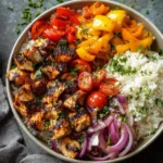 Colorful Mediterranean rice bowl with fresh vegetables and herbs.