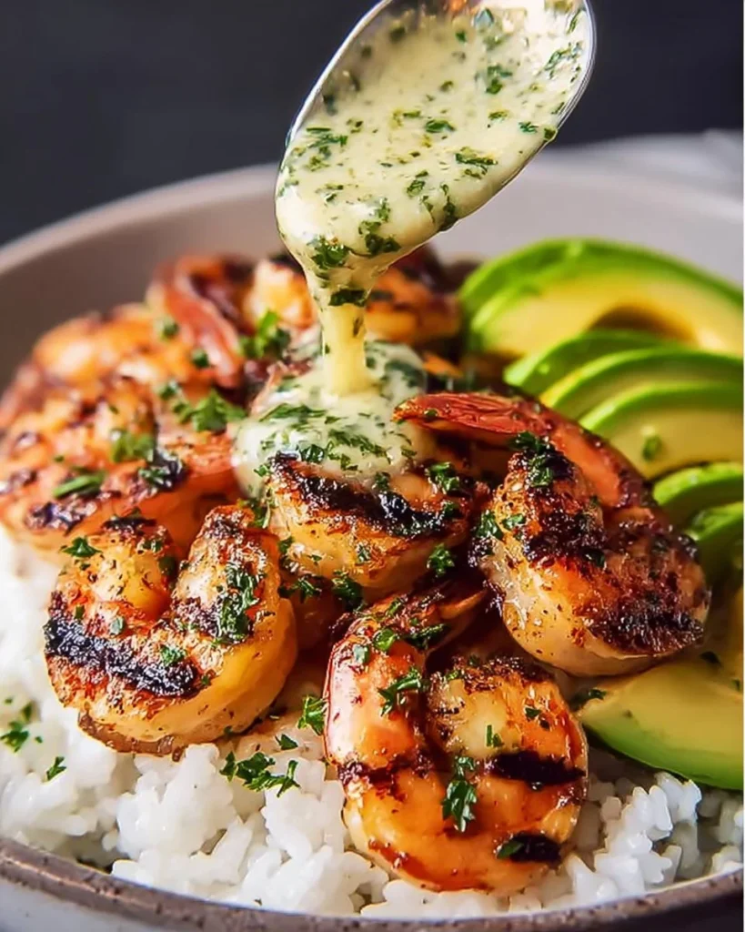 Mediterranean shrimp and avocado rice bowls garnished with fresh herbs and spices.