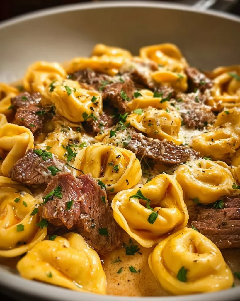 Savory cheesesteak tortellini in creamy provolone sauce served in a bowl