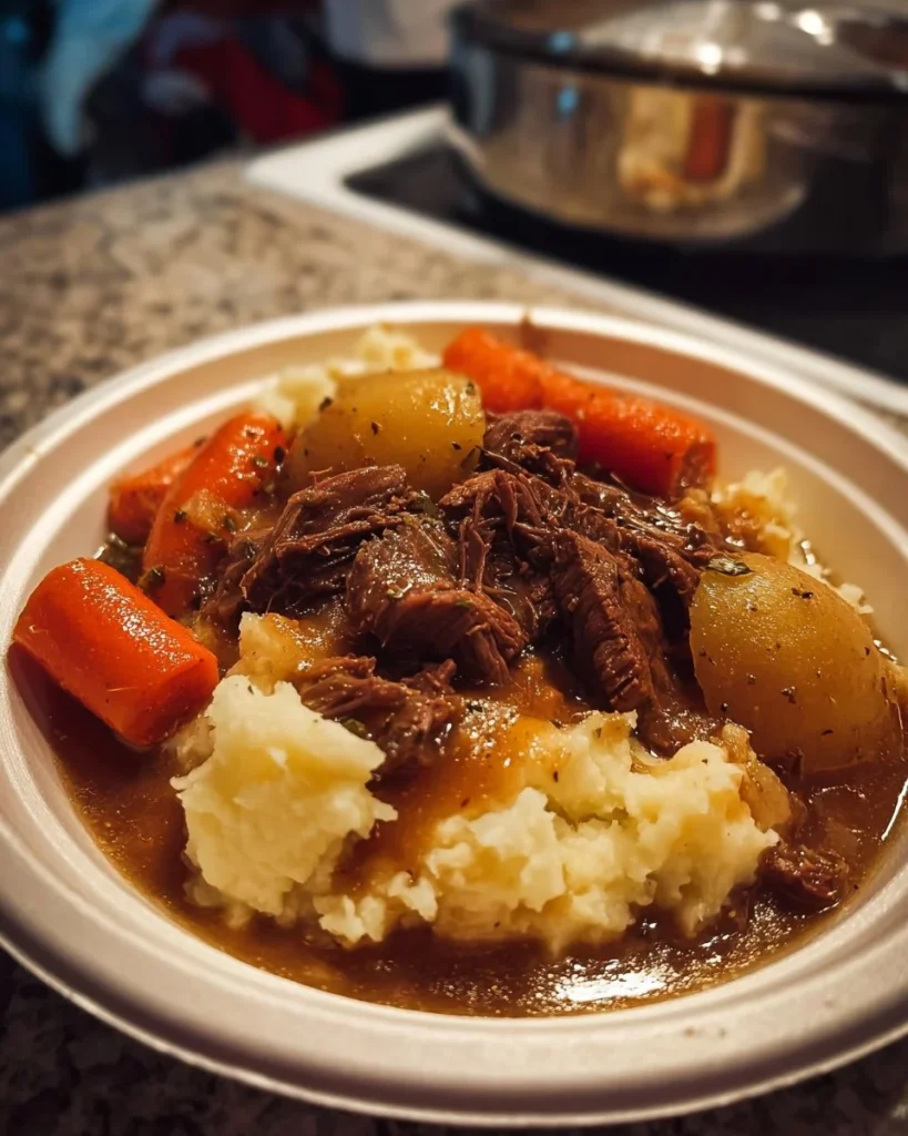 Delicious slow-cooked beef pot roast served over creamy mashed potatoes