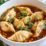 Bowl of Spicy Sichuan Wonton Soup with vibrant ingredients and garnish