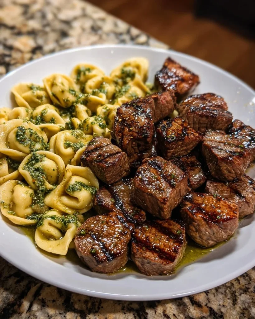 Tender steak bites served with pesto Alfredo tortellini sauce