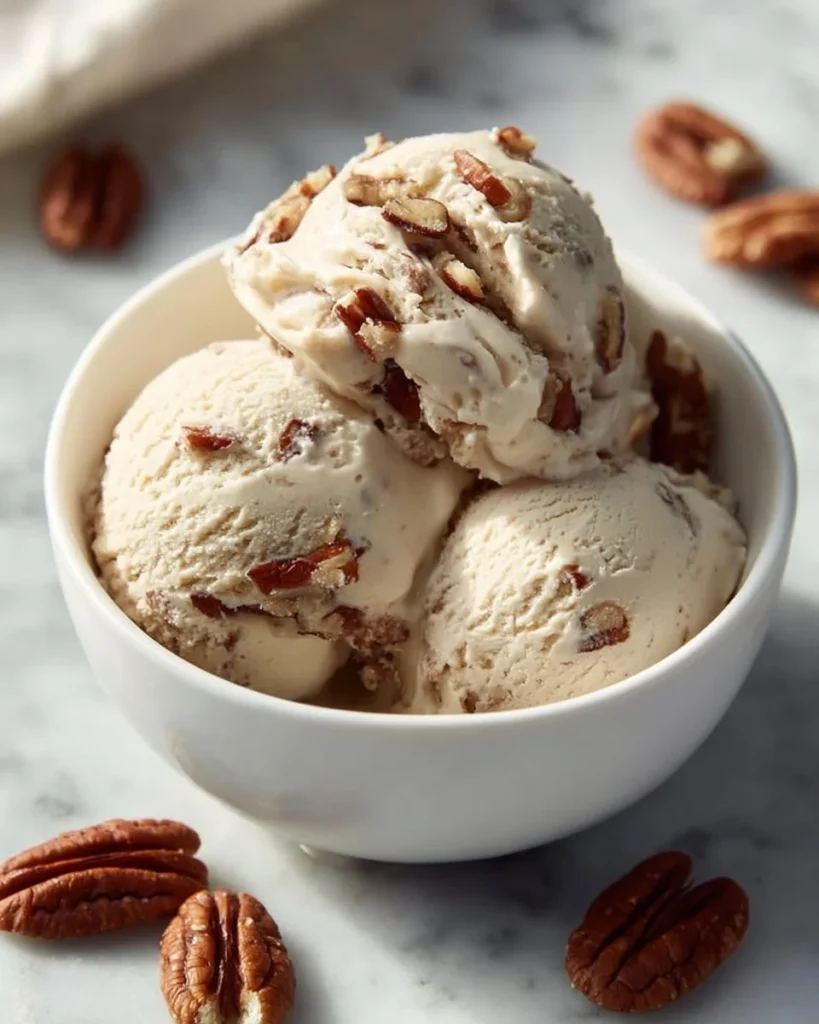 Vegan butter pecan ice cream in a bowl with pecans on top