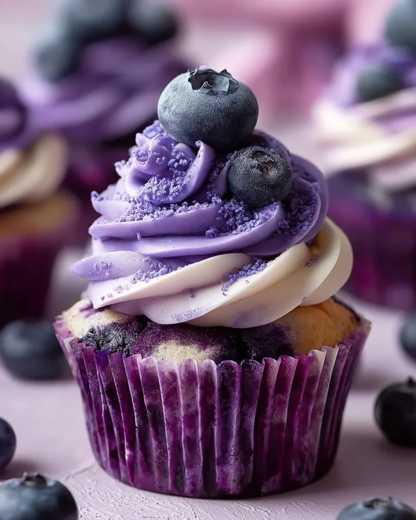 Delicious white chocolate blueberry cheesecake cupcakes topped with fresh blueberries.